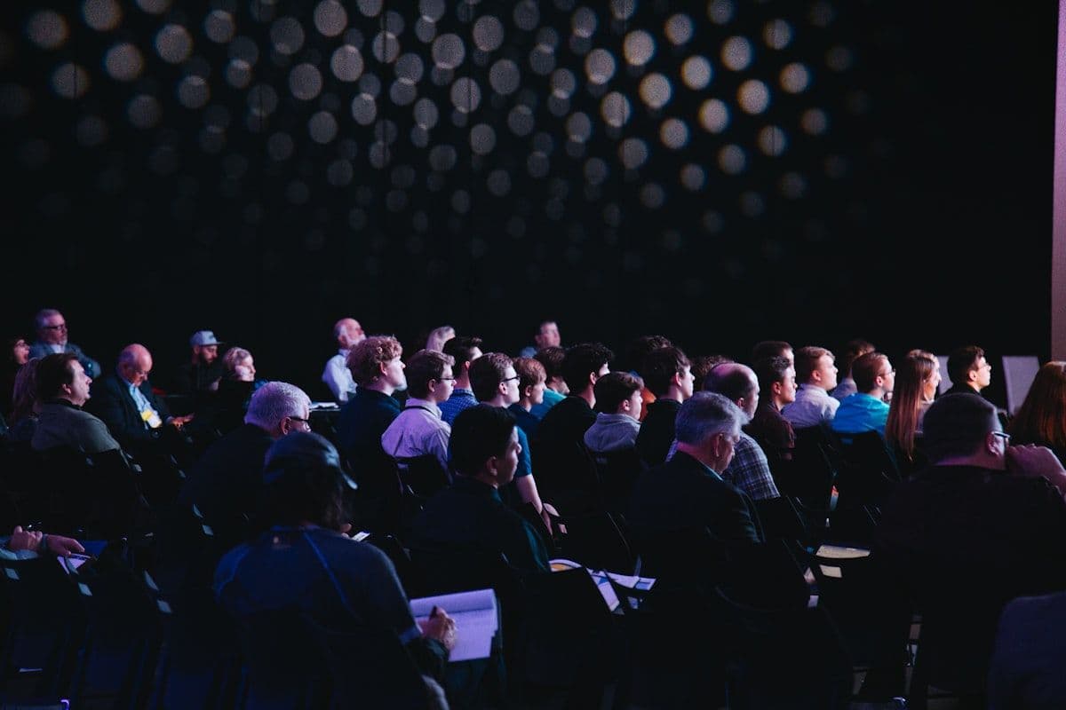 Large crowd at a political event with stage lights